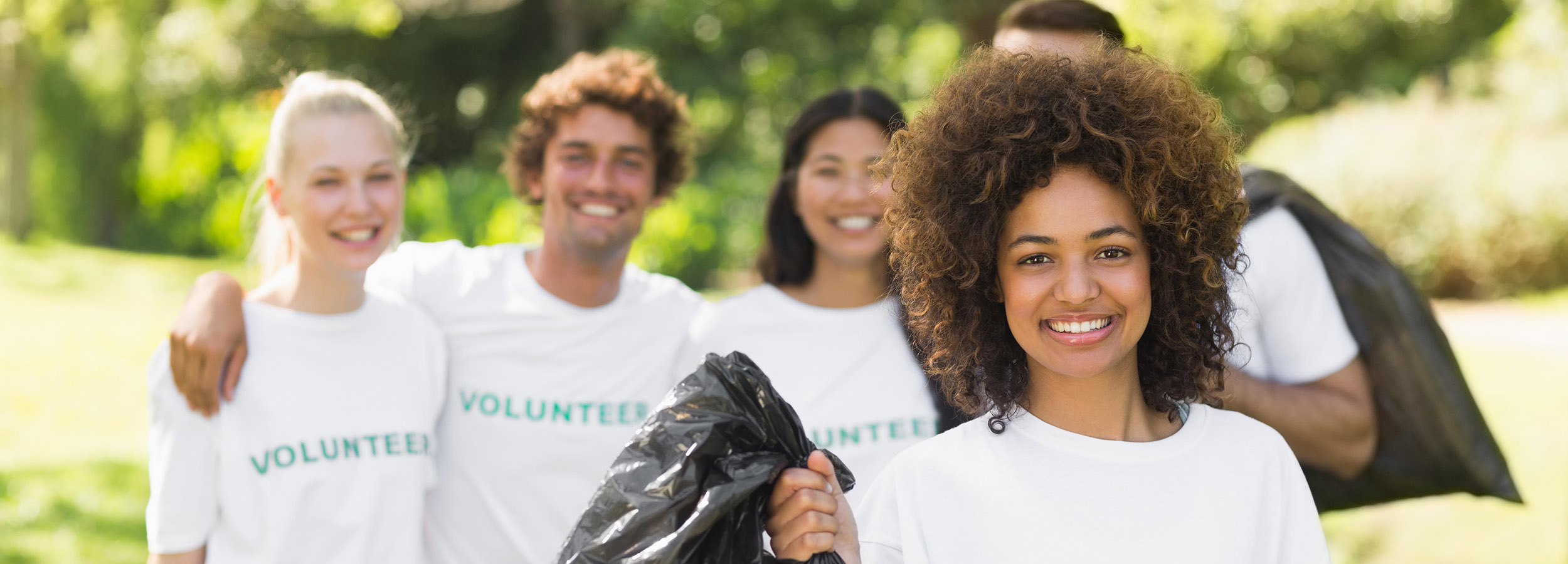 Team of volunteers picking up litter in park